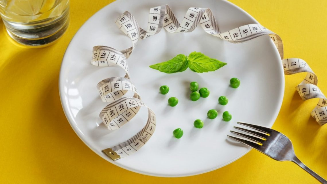 Diet white plate with centimeter peas and basil