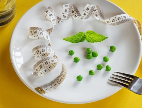 Diet white plate with centimeter peas and basil